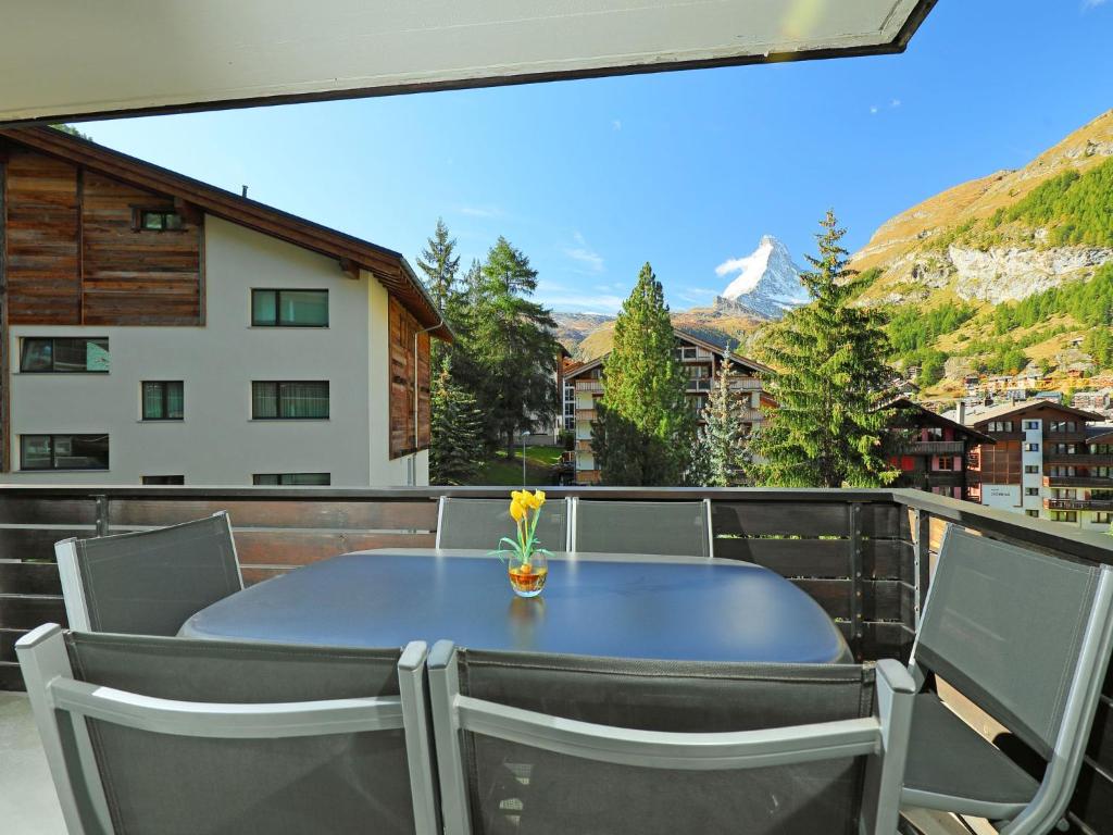 una mesa azul y sillas en el balcón en Apartment Roc by Interhome, en Zermatt