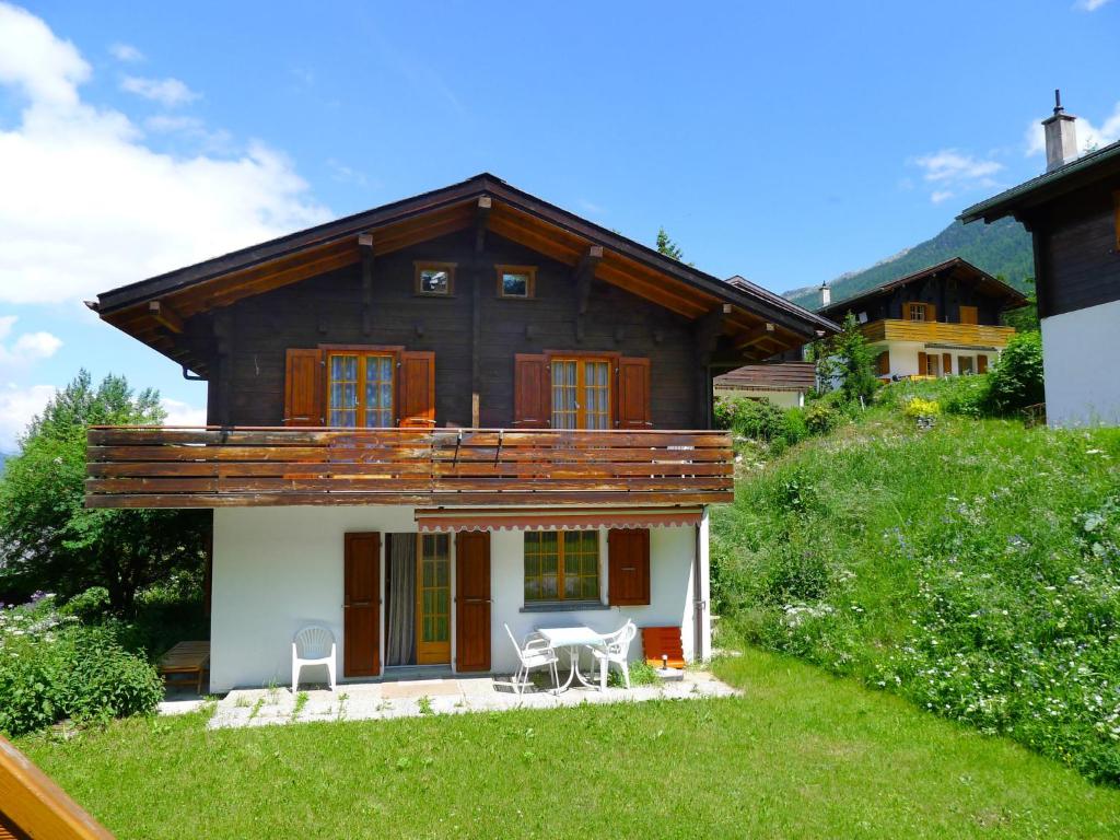 a house on a hill with two chairs in front of it at Chalet Allegra by Interhome in Grächen