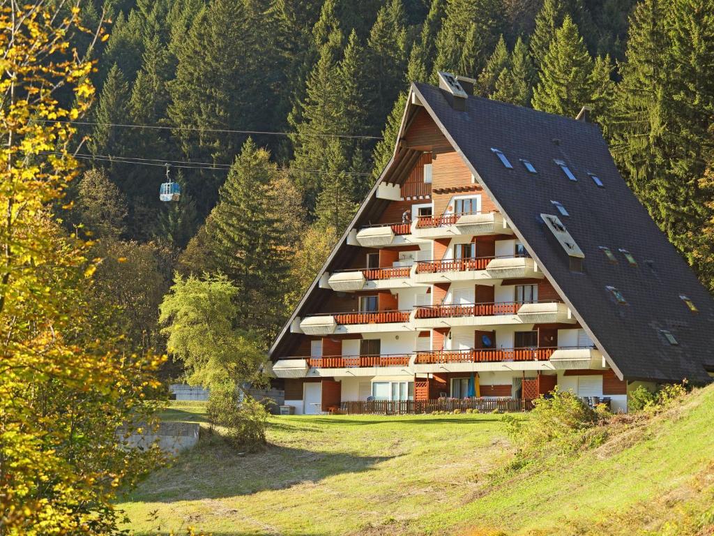 a building with a gambrel roof on top of a hill at Apartment Anémone 2-16 by Interhome in Arveyes