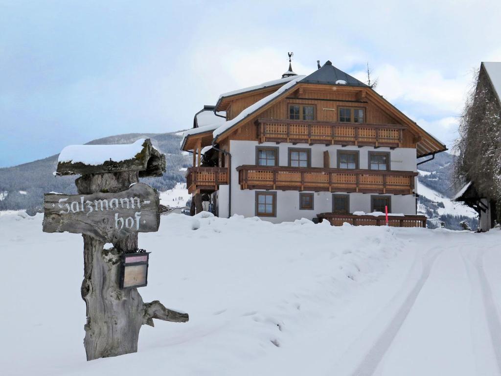 um sinal na neve em frente a uma casa em Apartment Salzmannhof - RMU210 by Interhome em Ramsau am Dachstein