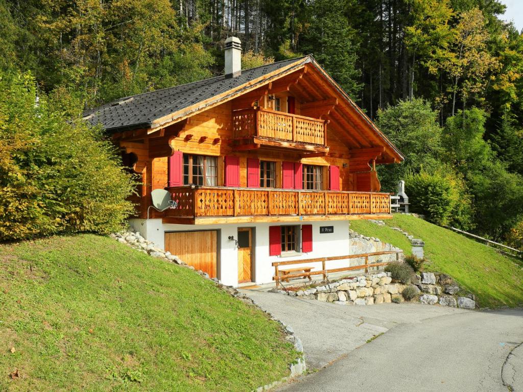 uma grande casa de madeira com uma varanda numa colina em Chalet Saint Piran by Interhome em Villars-sur-Ollon