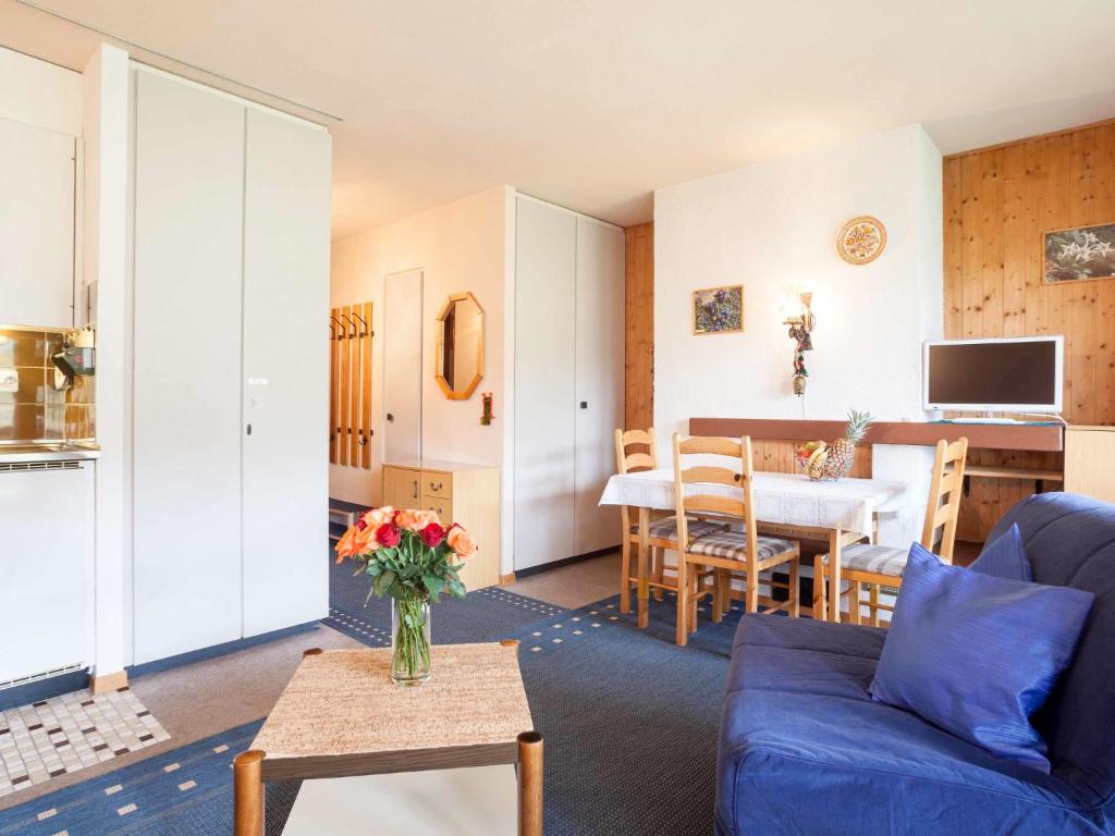a living room with a blue couch and a table at Studio Résidence Arzinol by Interhome in Les Collons