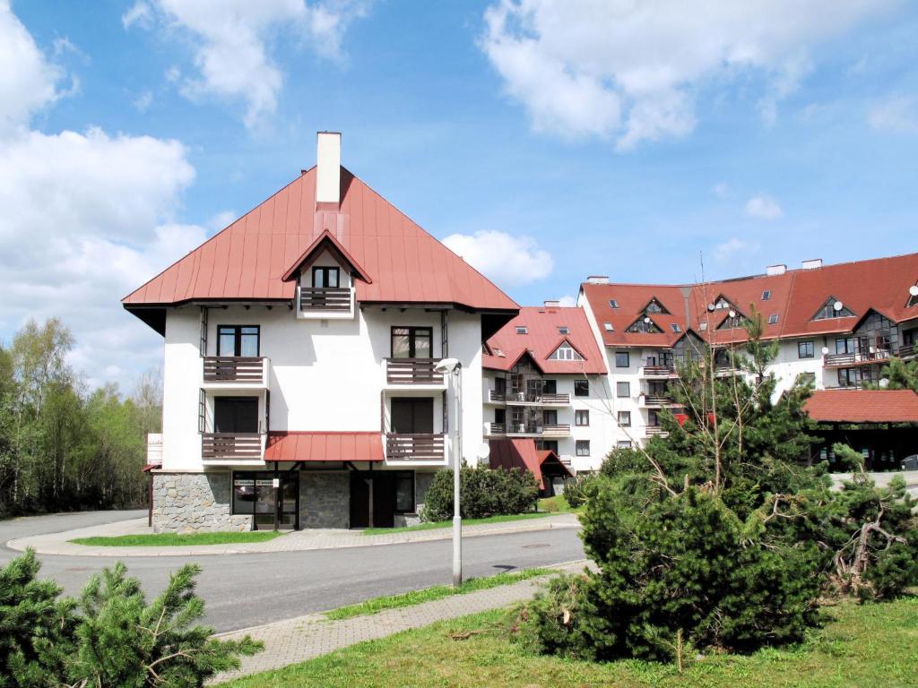 ein großes weißes Gebäude mit rotem Dach in der Unterkunft Apartment Klondajk - HRA120 by Interhome in Harrachov