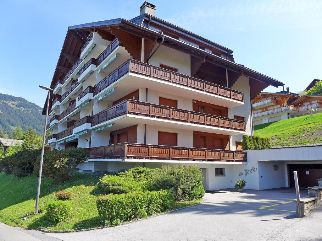 - un grand bâtiment avec des balcons sur le côté dans l'établissement Apartment Les Girolles B14 by Interhome, à Villars-sur-Ollon