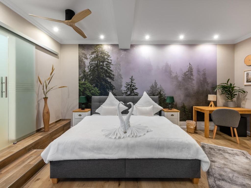 ein Schlafzimmer mit einem großen Bett mit einem großen Gemälde an der Wand in der Unterkunft Cityhotel Bernburg in Bernburg