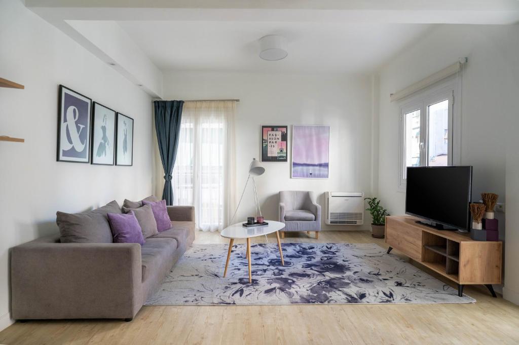 a living room with a couch and a tv at Athens Morum City Apartments in Athens