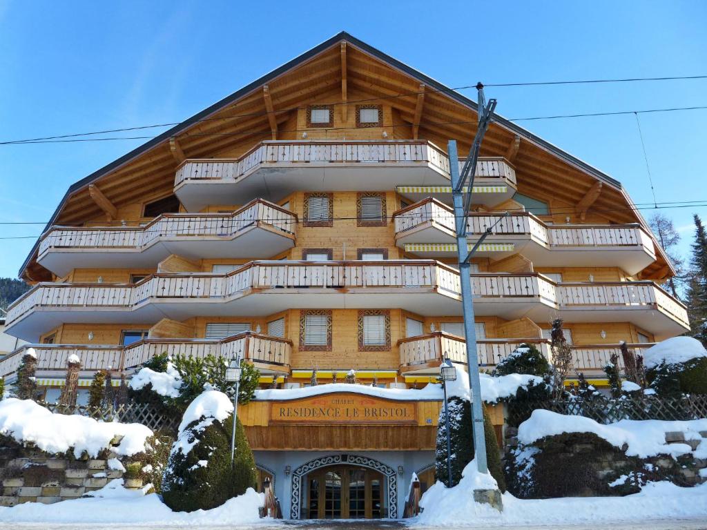 ein großes Holzgebäude mit Schnee davor in der Unterkunft Apartment Résidence Le Bristol 14 by Interhome in Villars-sur-Ollon