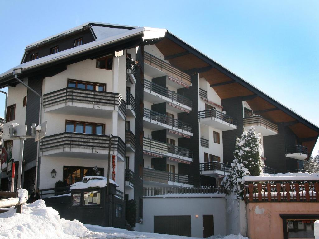 a large apartment building with balconies in the snow at Apartment Villars Soleil A27 by Interhome in Villars-sur-Ollon