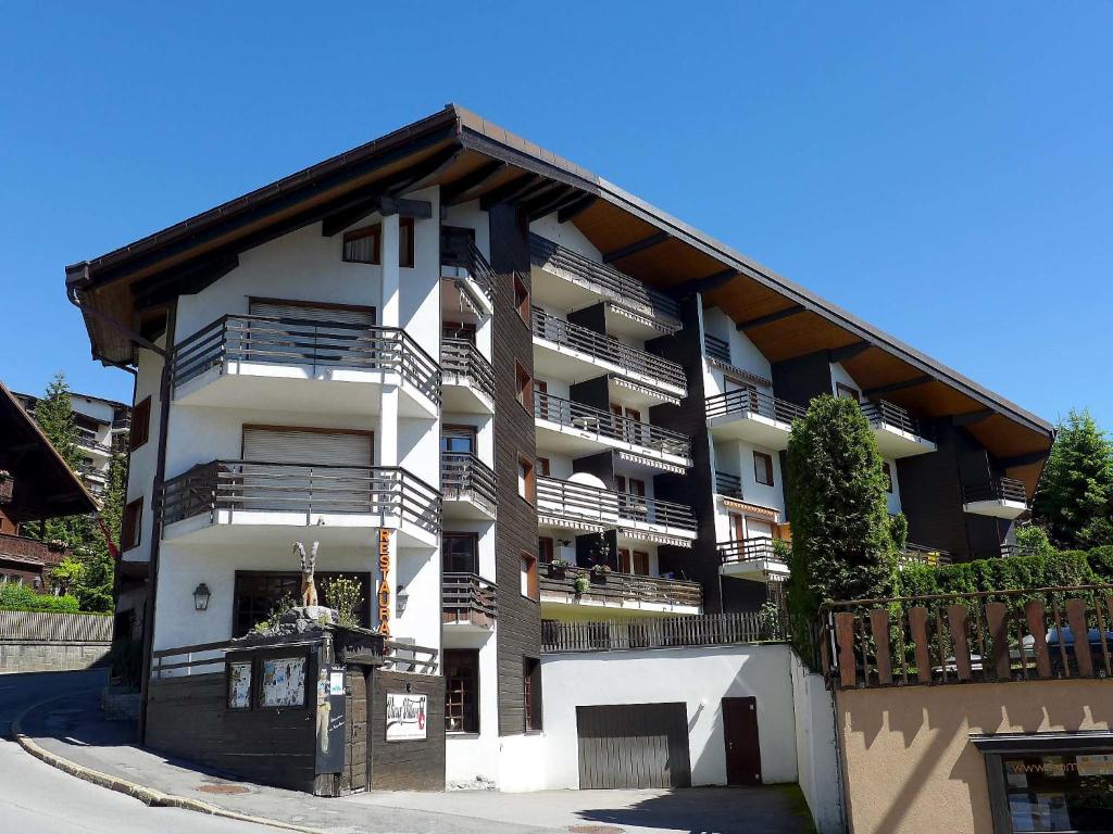 - un grand bâtiment avec des balcons sur le côté dans l'établissement Apartment Villars Soleil A27 by Interhome, à Villars-sur-Ollon