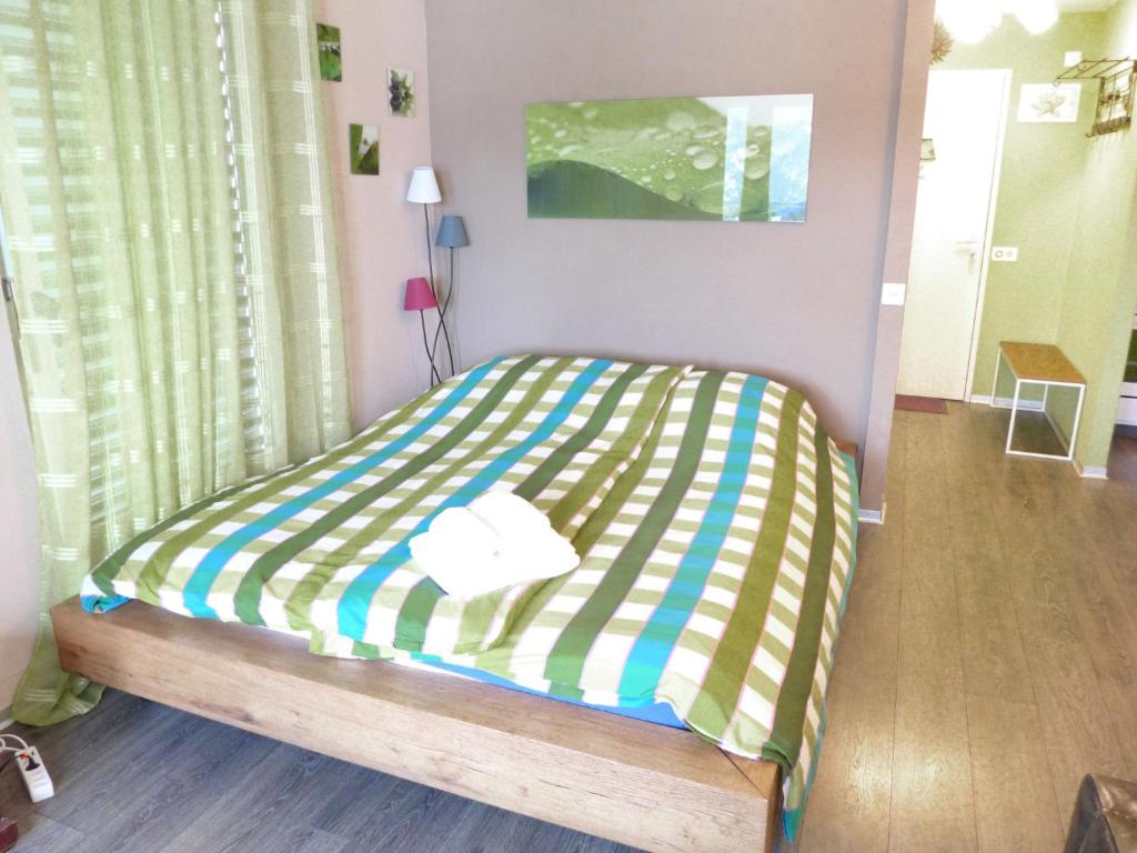 a bedroom with a bed with a striped blanket at Apartment Jeanne D'Arc Apt- C-28 by Interhome in Crans-Montana