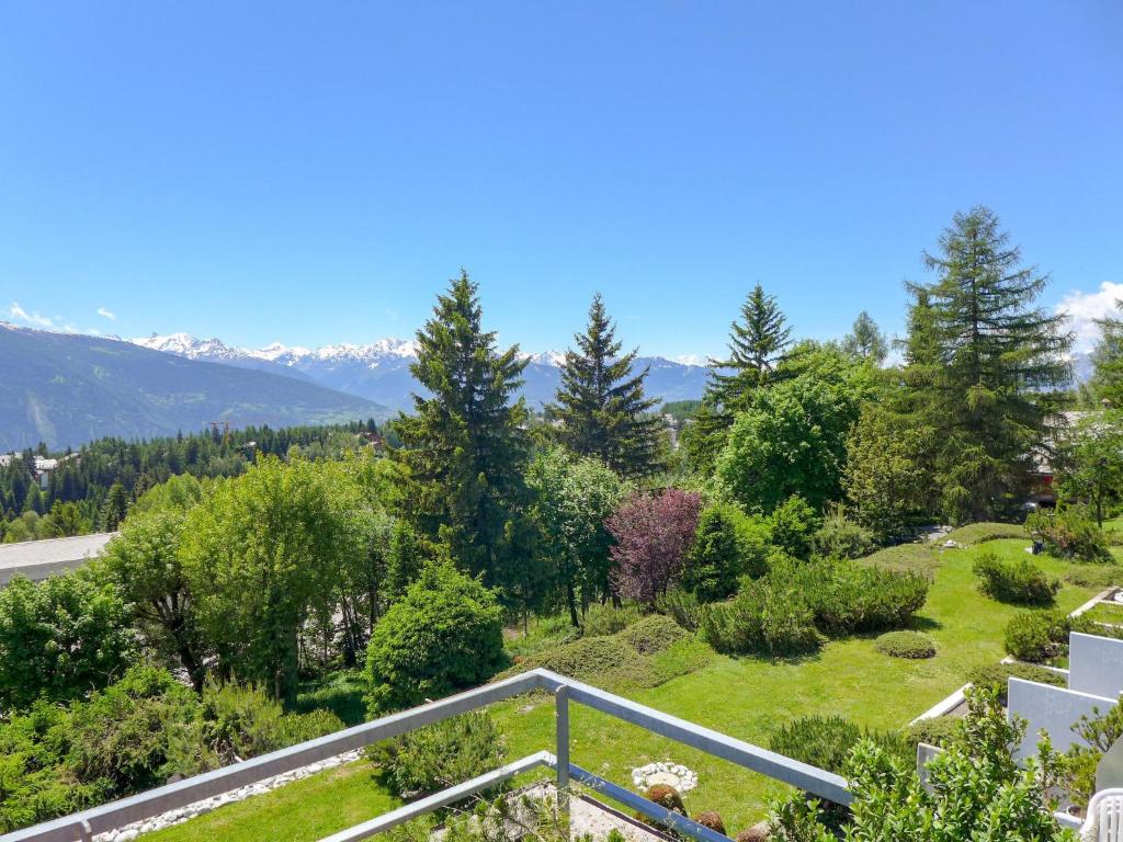 a view of a garden from the balcony of a house at Apartment Jeanne D'Arc Apt- C-28 by Interhome in Crans-Montana