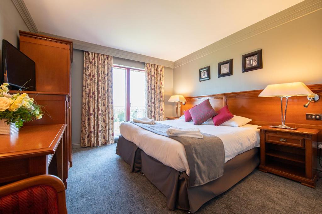 a hotel room with a large bed and a desk at Bryn Meadows Golf, Hotel & Spa in Blackwood