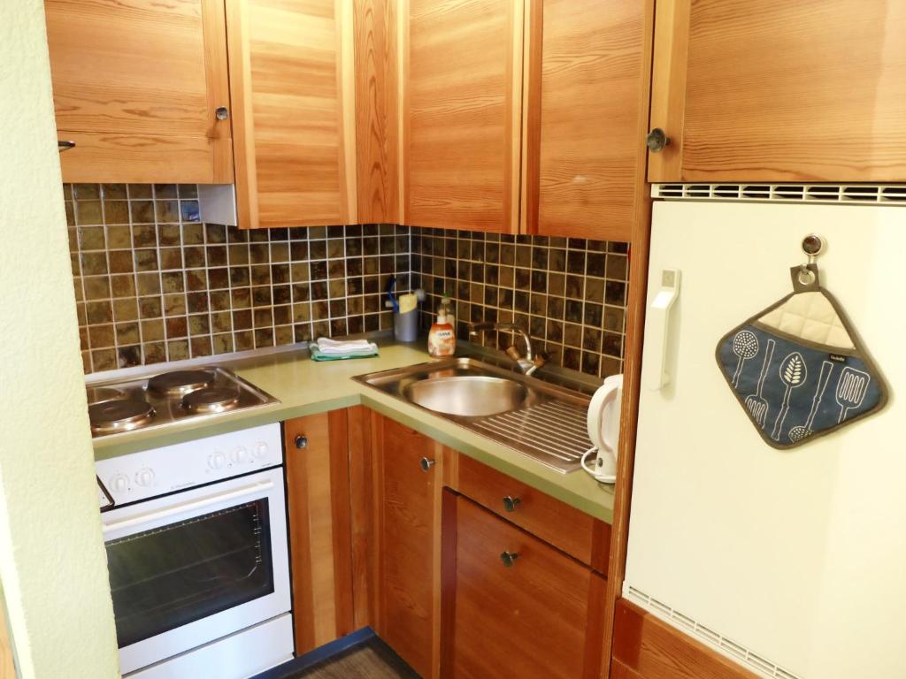 a small kitchen with a sink and a refrigerator at Apartment Jeanne D'Arc Apt- C-28 by Interhome in Crans-Montana
