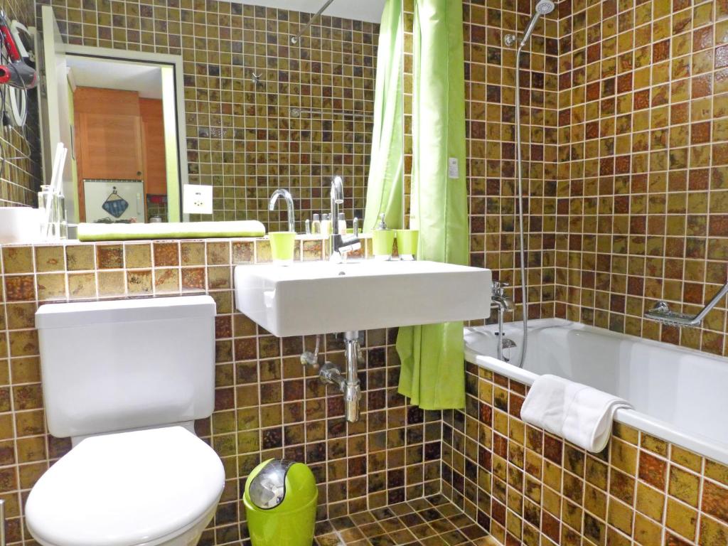 a bathroom with a toilet and a sink and a tub at Apartment Jeanne D'Arc Apt- C-28 by Interhome in Crans-Montana