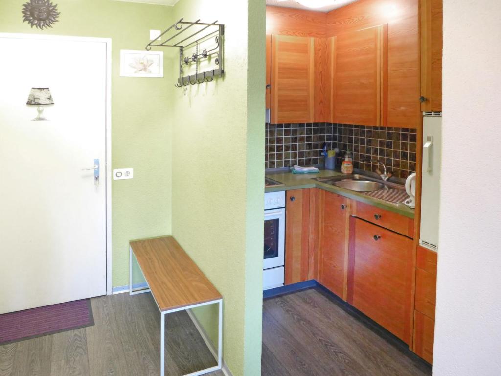a kitchen with wooden cabinets and a table in it at Apartment Jeanne D'Arc Apt- C-28 by Interhome in Crans-Montana