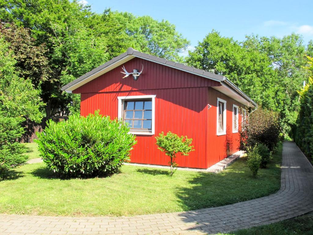 a red shed with a window in a yard at Chalet Nachtigall by Interhome in Osten