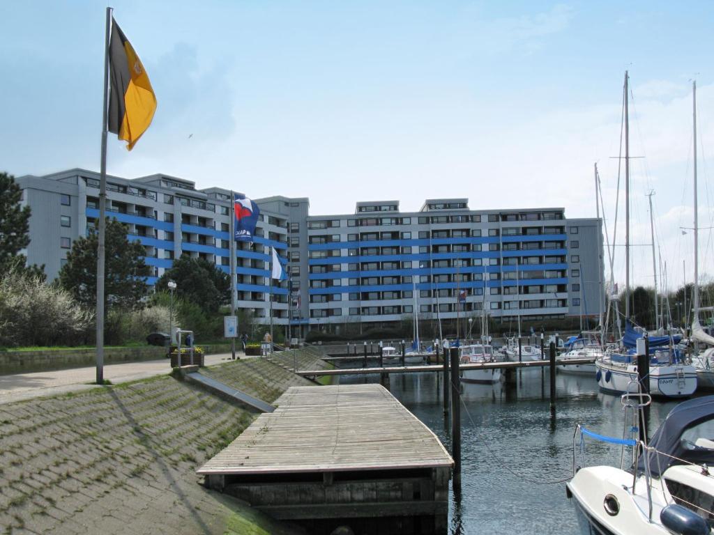 a building with a flag in front of a marina at Apartment Ostsee-Residenz - DMP173 by Interhome in Damp