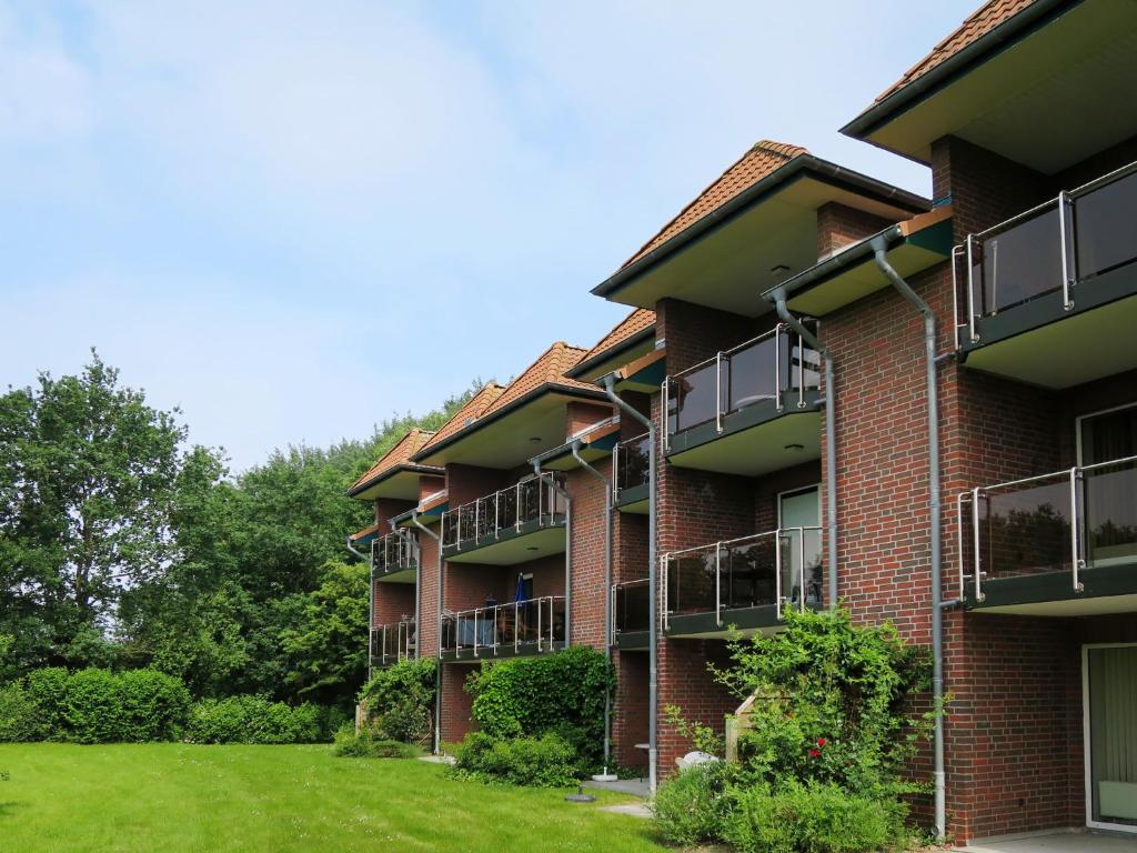 un edificio de ladrillo rojo con balcones y patio en Apartment Cuxland Ferienpark-2 by Interhome, en Wremen