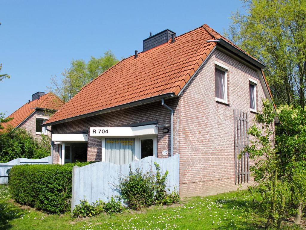 トッセンスにあるHoliday Home Tossens-5 by Interhomeの赤い屋根の小さなレンガ造りの家
