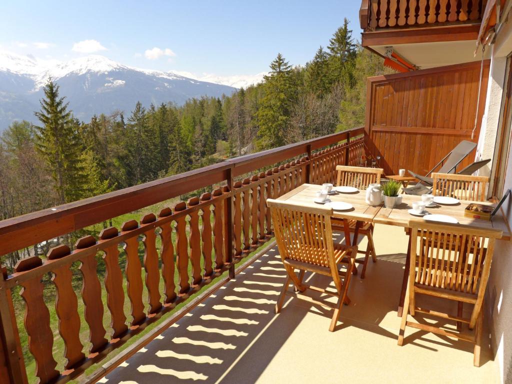 una mesa en un balcón con vistas a las montañas en Apartment Marigny Andolla by Interhome, en Crans-Montana