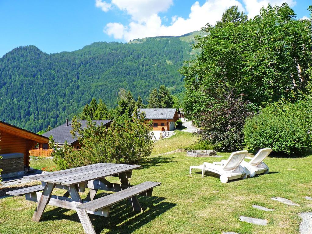 una mesa de picnic y dos sillas en el césped en Chalet Six des Armailles by Interhome, en Ovronnaz