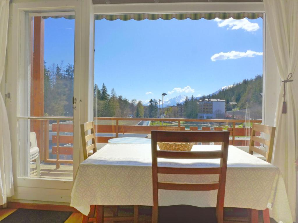 einen Tisch und einen Stuhl in einem Zimmer mit Fenster in der Unterkunft Apartment Le Farinet-1 by Interhome in Crans-Montana