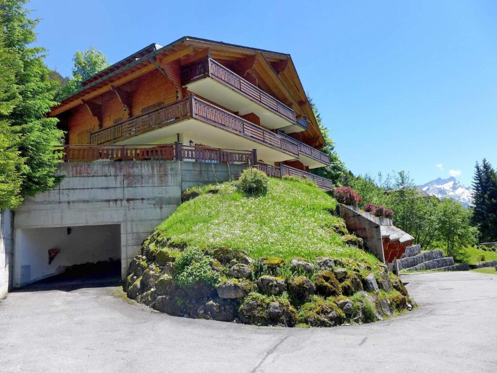 a building with a grassy hill in front of it at Apartment Le Faucon 7 by Interhome in Villars-sur-Ollon