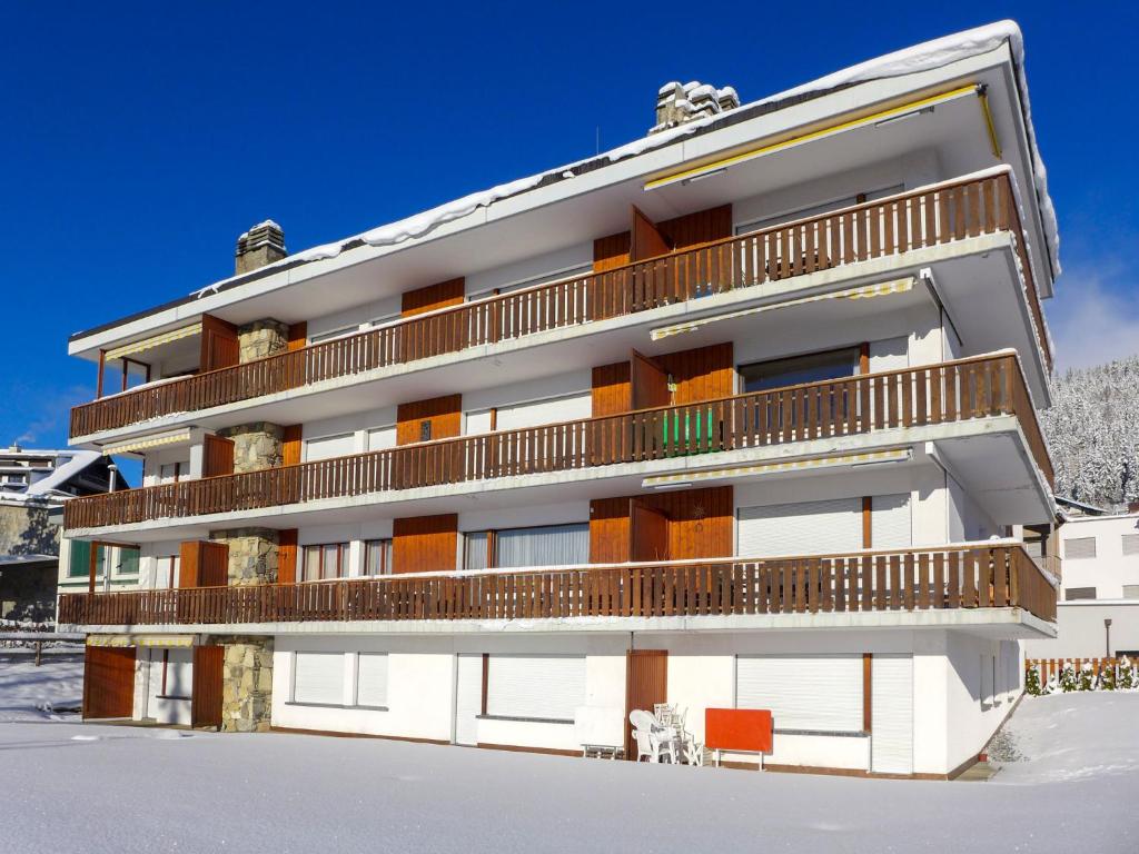 a building with balconies on it in the snow at Apartment Andrea B15 by Interhome in Vermala
