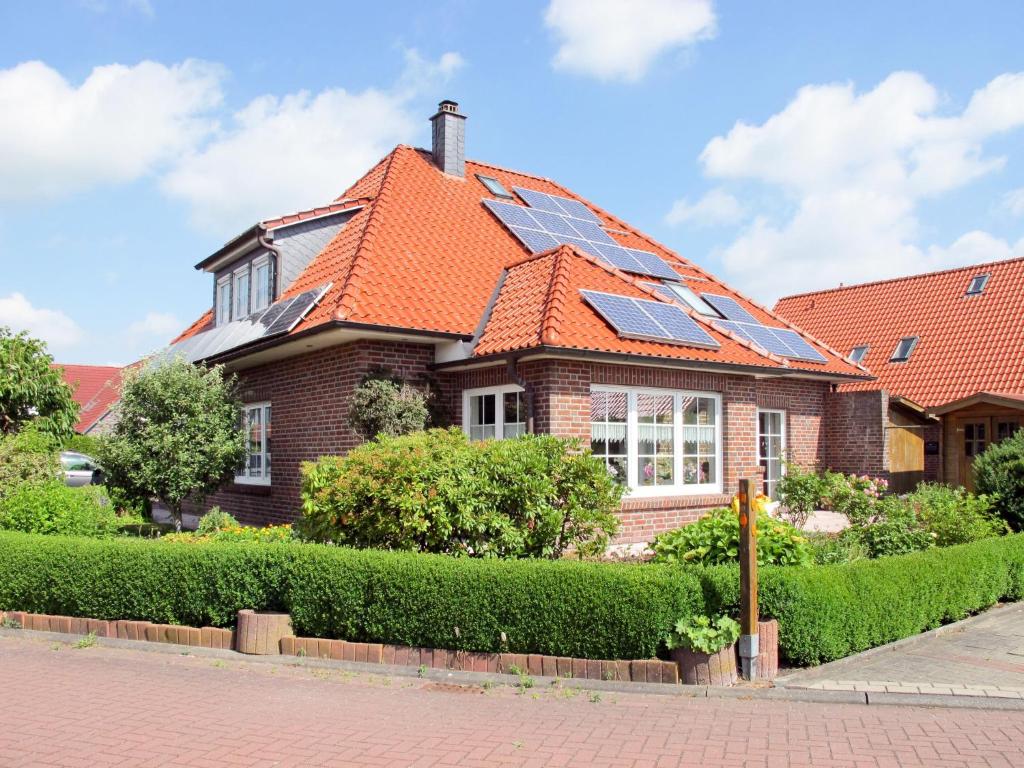 uma casa de tijolos com painéis solares no telhado em Apartment Marianne by Interhome em Hooksiel