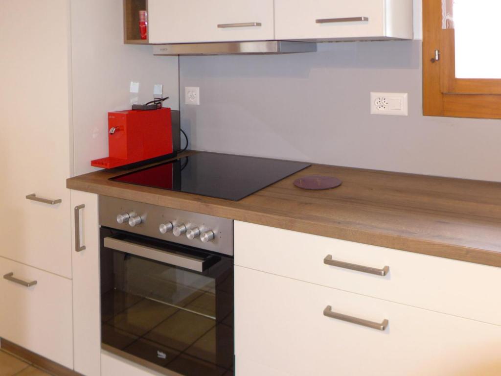 uma cozinha com armários brancos e um forno com placa de fogão em Chalet Hügli by Interhome em Bure
