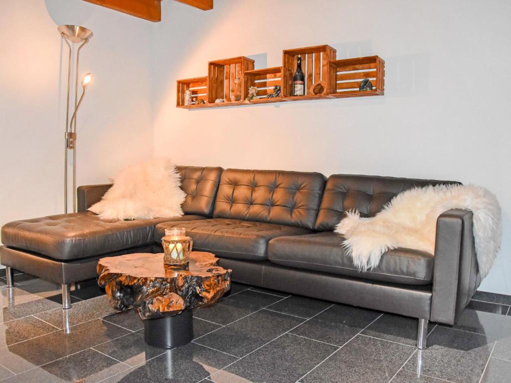 sala de estar con sofá de cuero marrón y mesa en Holiday Home Casa Anna by Interhome, en Agarone