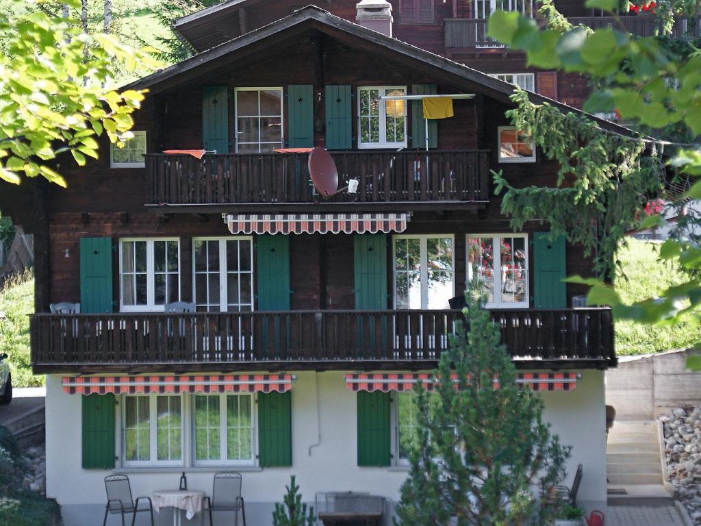 una casa con balcón en la parte superior en Apartment Chalet Spassvogel by Interhome en Grindelwald