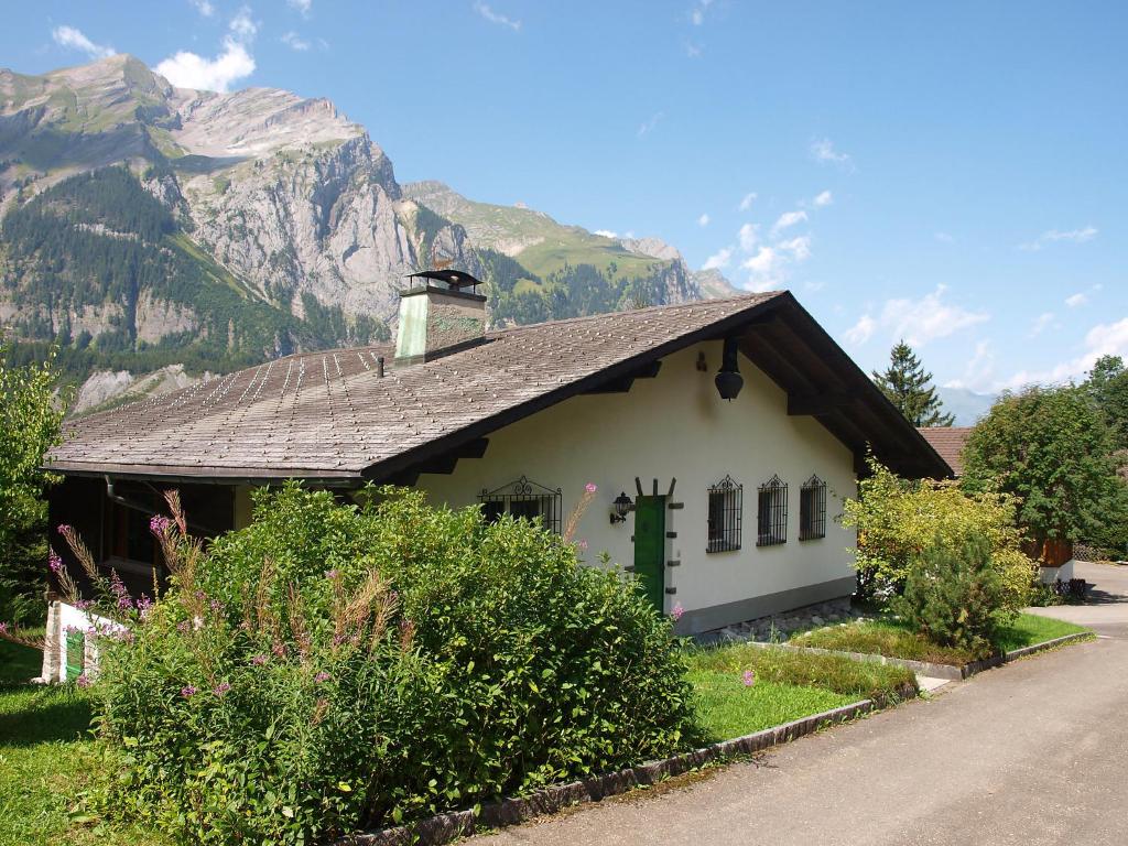 ein kleines weißes Haus mit einem Berg im Hintergrund in der Unterkunft Holiday Home Chalet Marietta by Interhome in Kandersteg