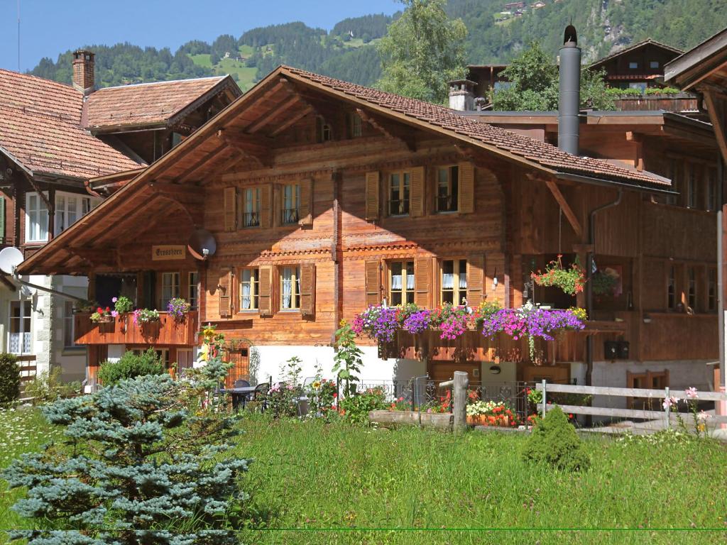 a wooden house with flowers in front of it at Apartment Grosshorn by Interhome in Lauterbrunnen