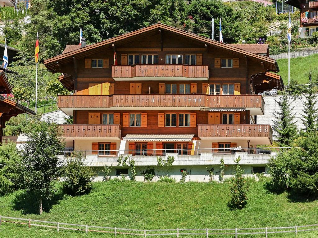 a large building with balconies on top of a hill at Apartment Chalet Perle by Interhome in Grindelwald