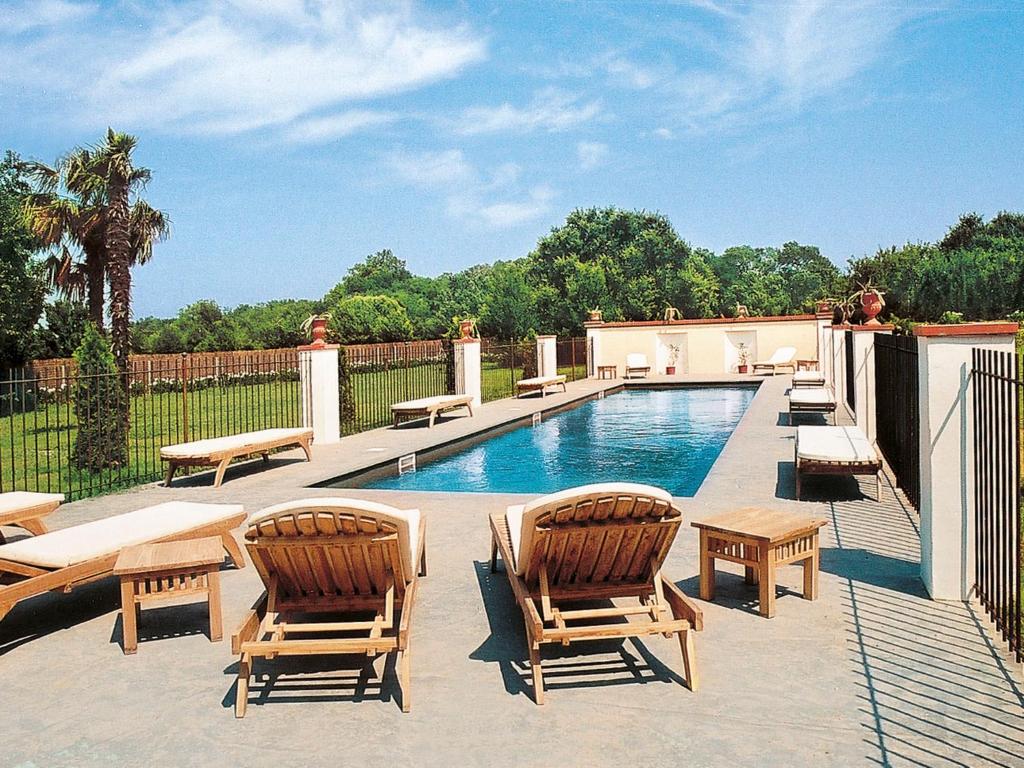 Le RacouにあるHoliday Home Villa Jaume by Interhomeの芝生の椅子2脚とプールが備わるスイミングプールを併設しています。