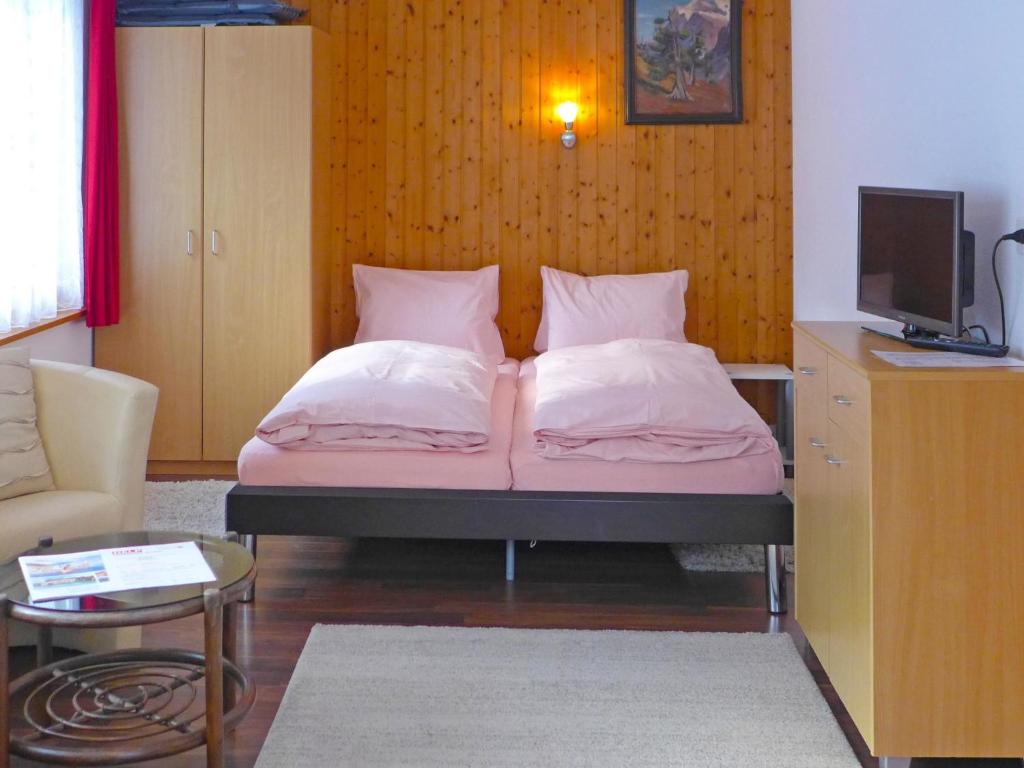 uma cama com duas almofadas num quarto em Apartment Chalet Bärgsunna-2 by Interhome em Grindelwald
