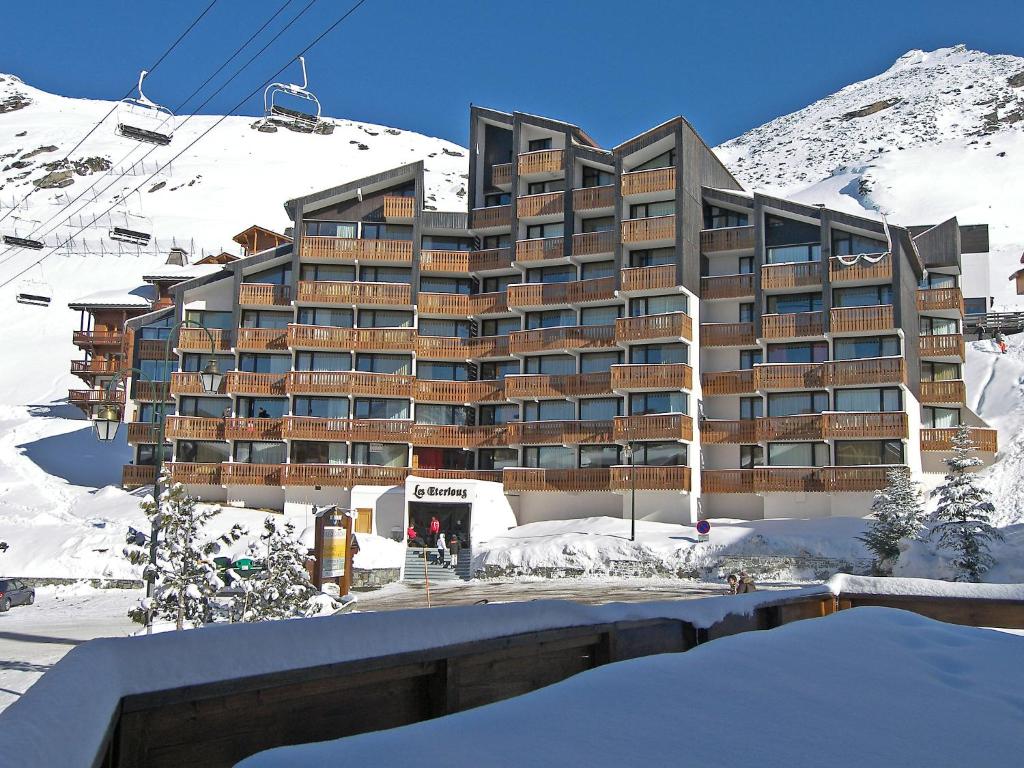 un grand bâtiment dans la neige avec une montagne dans l'établissement Apartment Les Eterlous by Interhome, à Val Thorens
