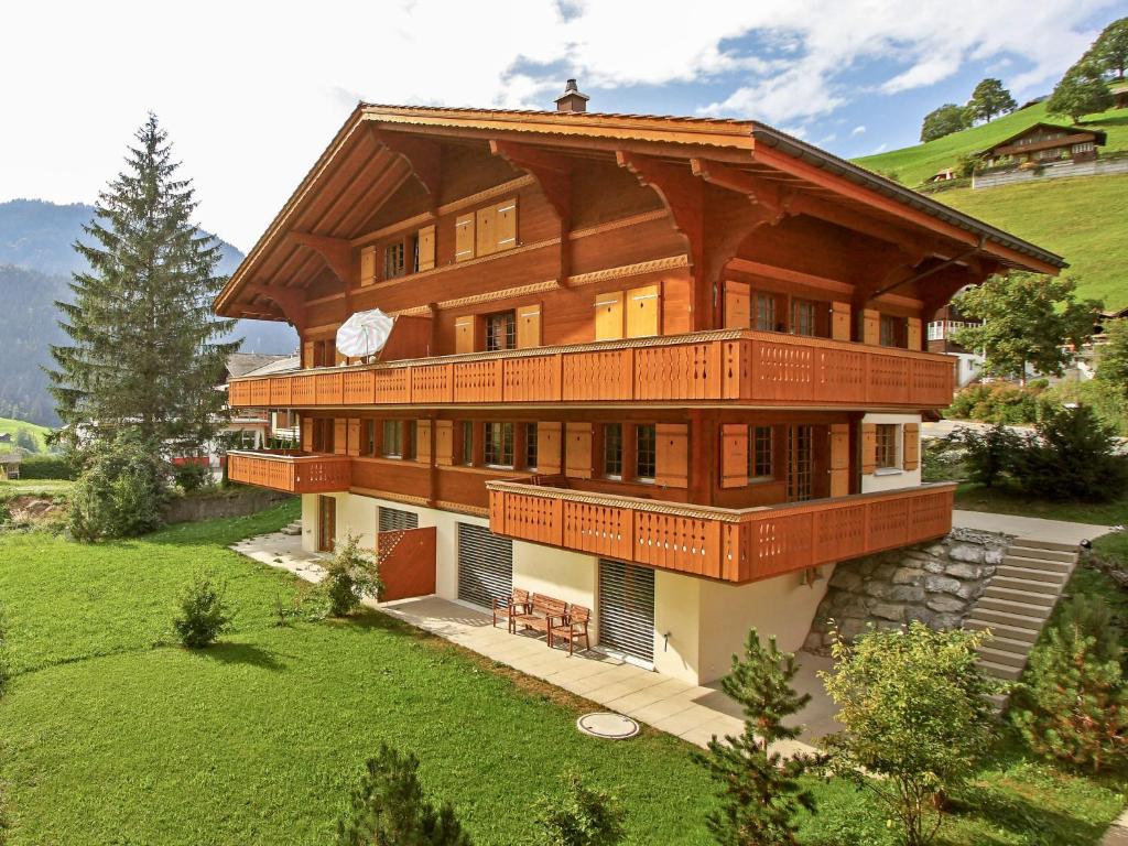 a large wooden house with a balcony at Apartment Chalet Eiger-1 by Interhome in Grindelwald