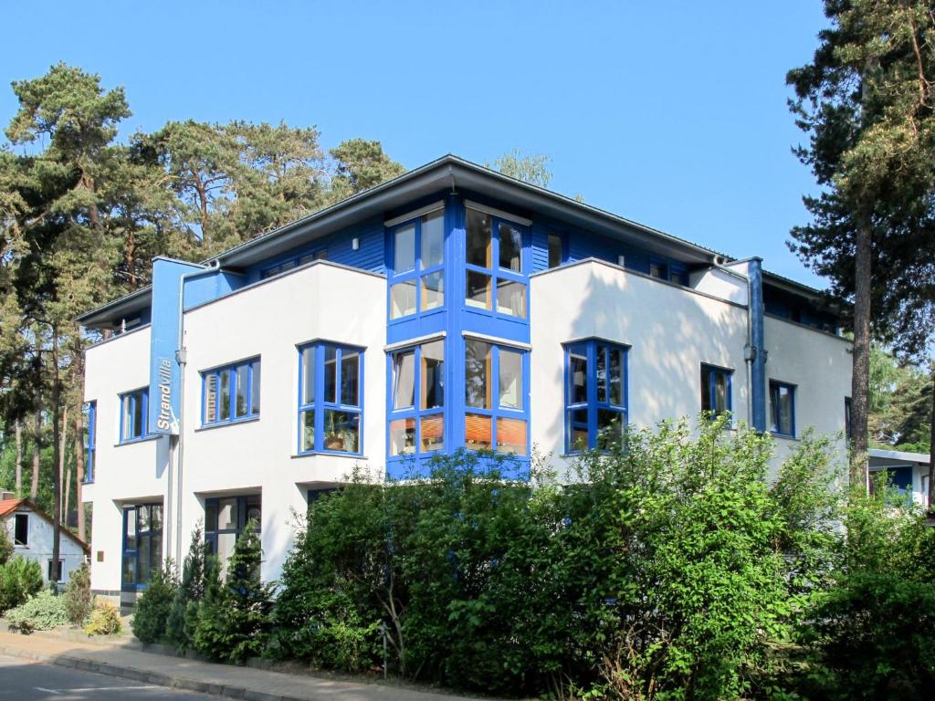 ein weißes Haus mit blauem Schnitt in der Unterkunft Apartment Strandvilla - LUB111 by Interhome in Lubmin
