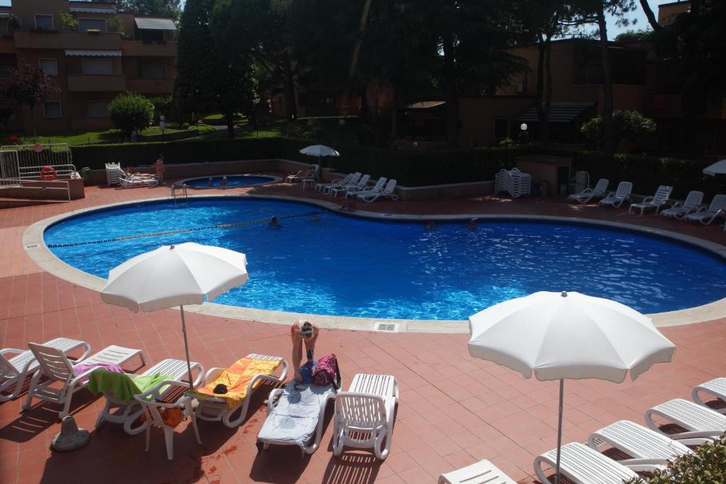 a swimming pool with chairs and umbrellas at Sweet Appartment di Guido in Peschiera del Garda