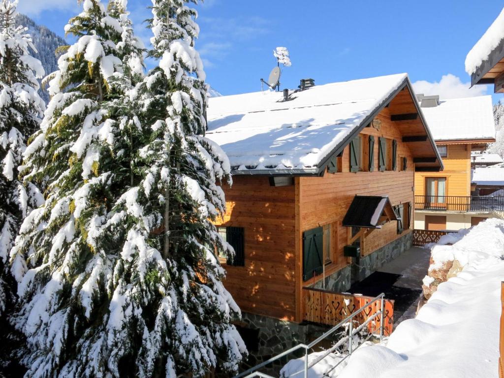 een blokhut in de sneeuw met een met sneeuw bedekte boom bij Apartment Fer à Cheval-2 by Interhome in Châtel