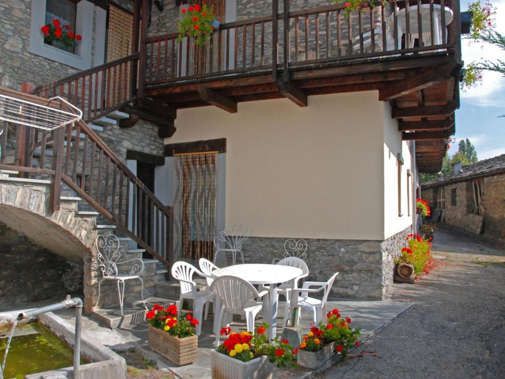 eine Terrasse mit einem Tisch und Stühlen sowie einem Balkon in der Unterkunft Apartment Grand Sarriod-1 by Interhome in Saint Nicolas