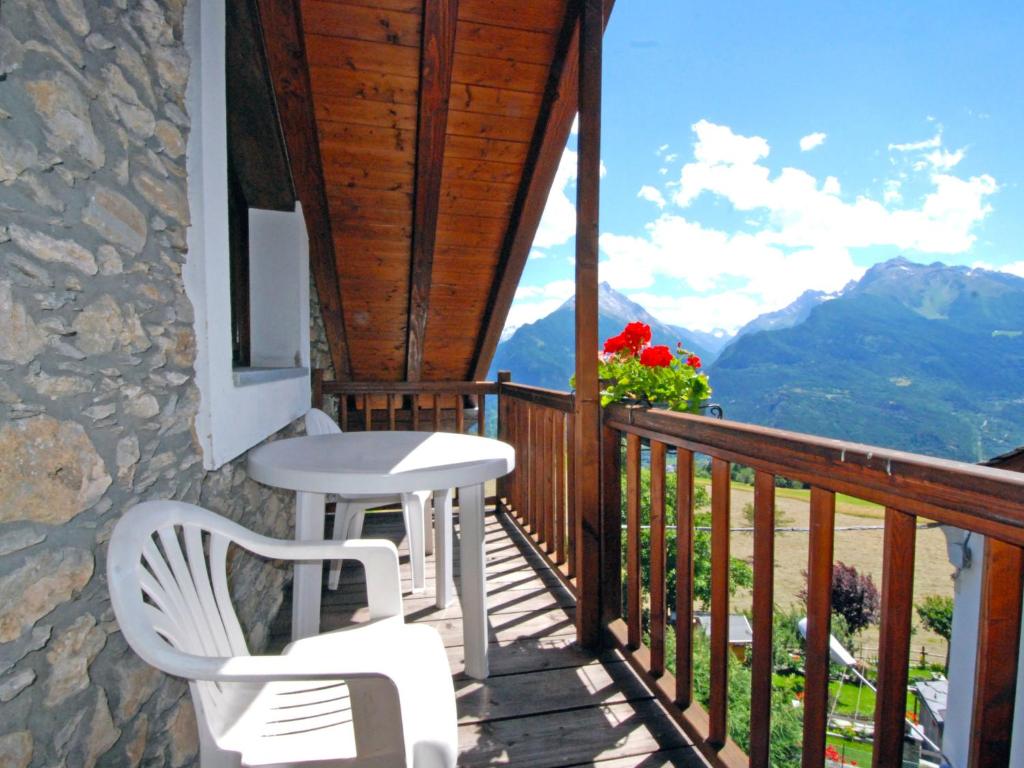 a balcony with two white chairs and a table at Apartment Grand Sarriod by Interhome in Saint Nicolas