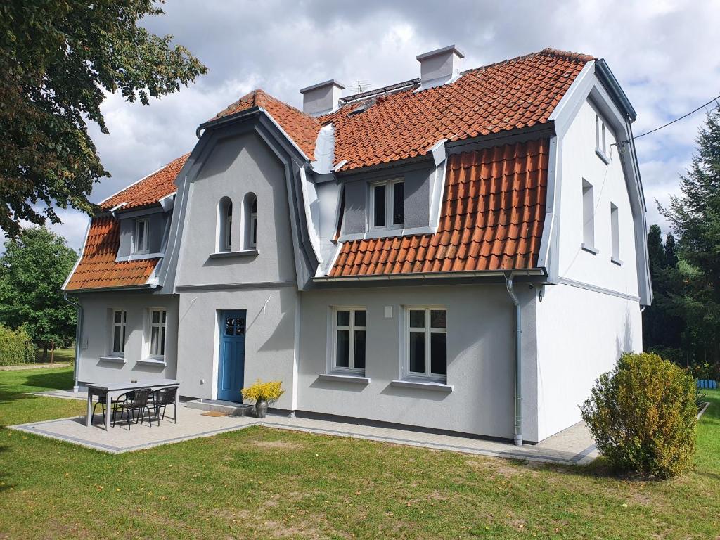 Casa blanca con techo rojo en Apartamenty Święta Lipka, en Święta Lipka