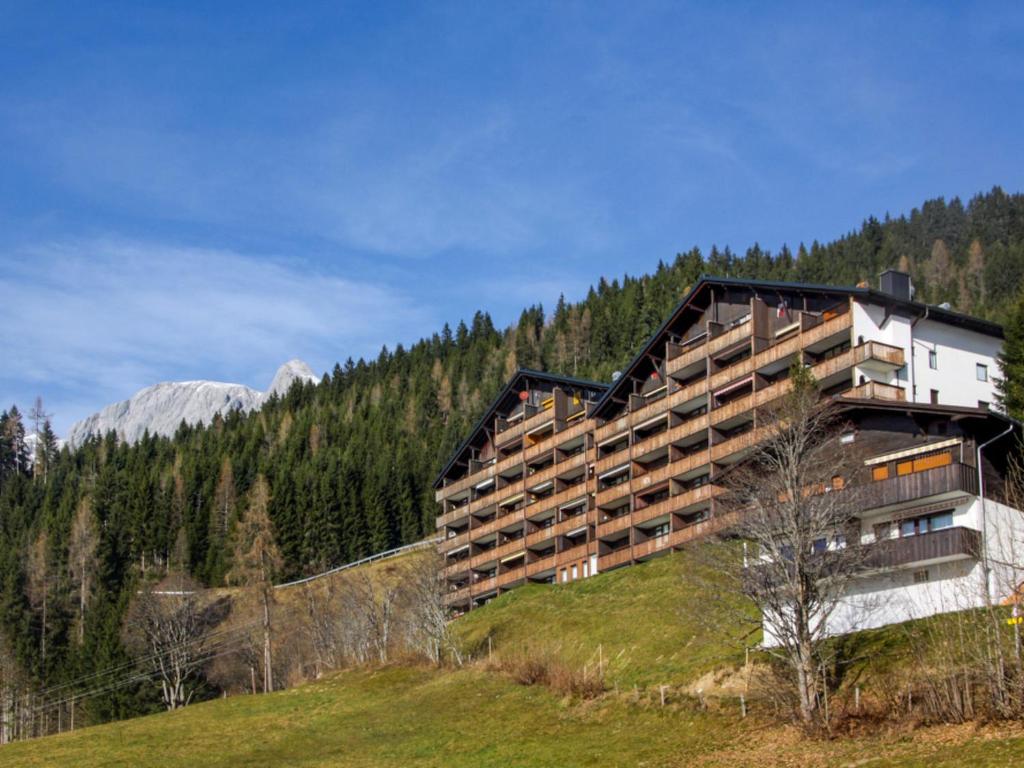 um grande edifício numa colina nas montanhas em Apartment Sonnenhang-1 by Interhome em Grünholzer