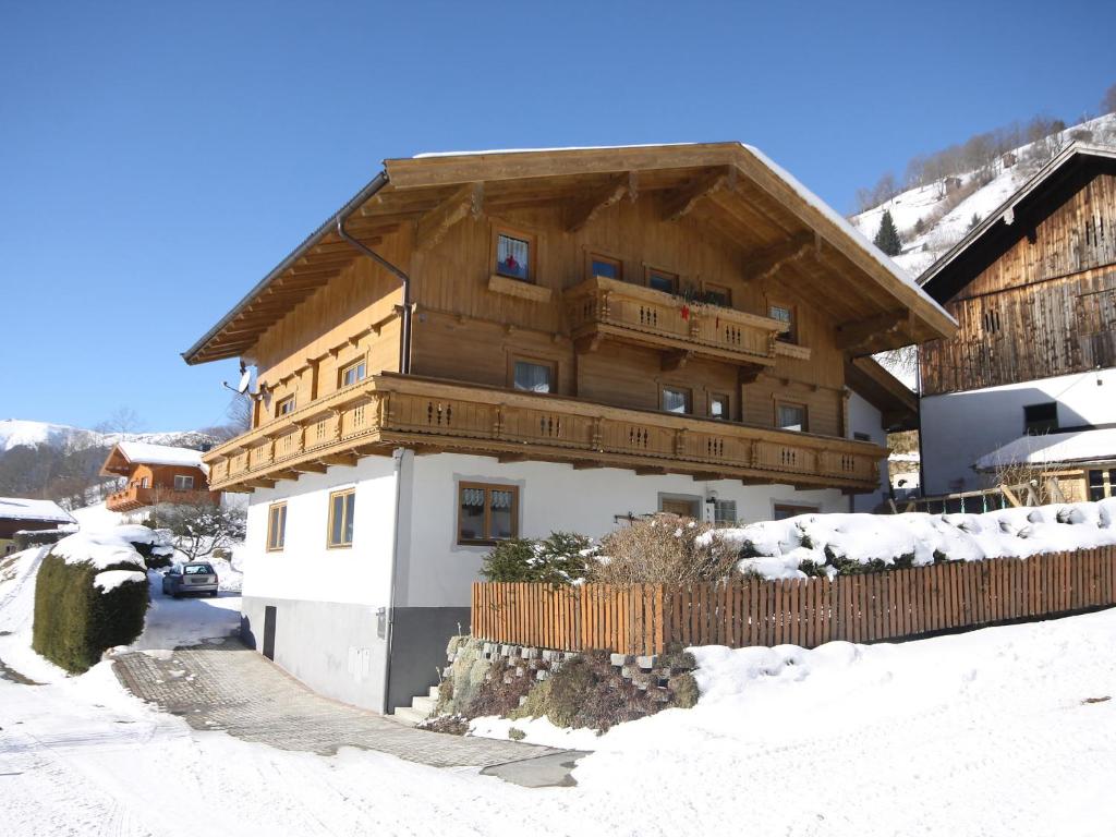 a large wooden building with snow on the ground at Apartment Ratgebgut by Interhome in Zell am See