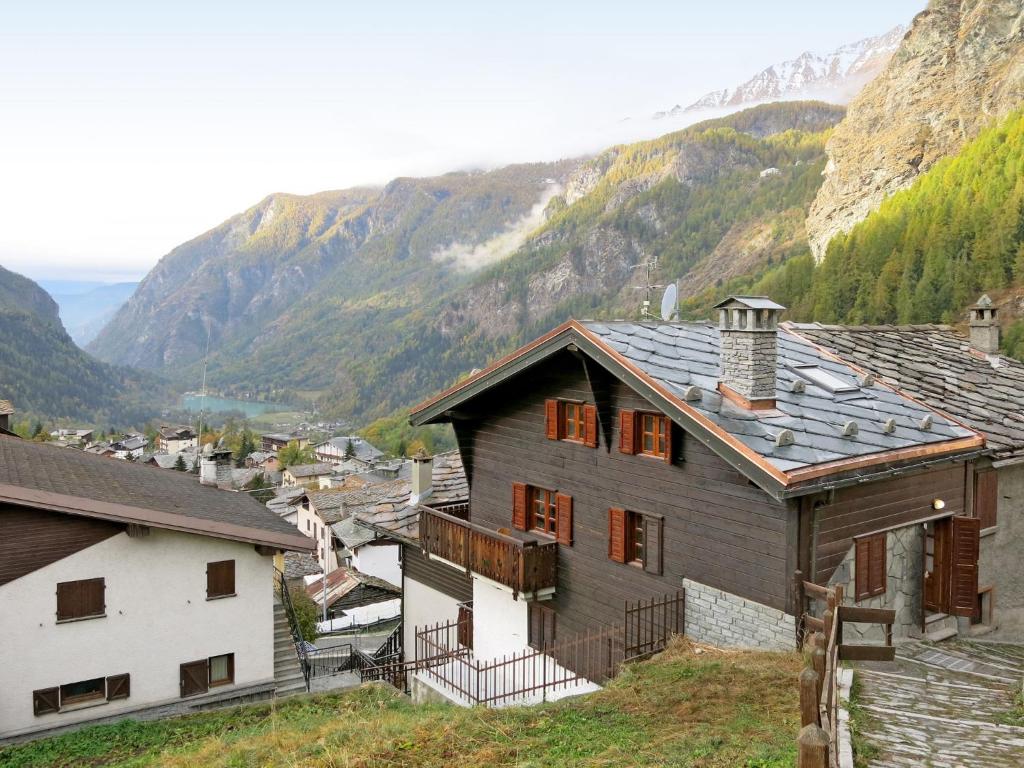 a house in a village with mountains in the background at Apartment Plen Solei by Interhome in Valtournenche