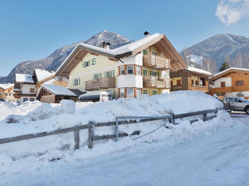 ein schneebedecktes Haus mit einem Schneehaufen in der Unterkunft Apartment Maura-2 by Interhome in Pozza di Fassa