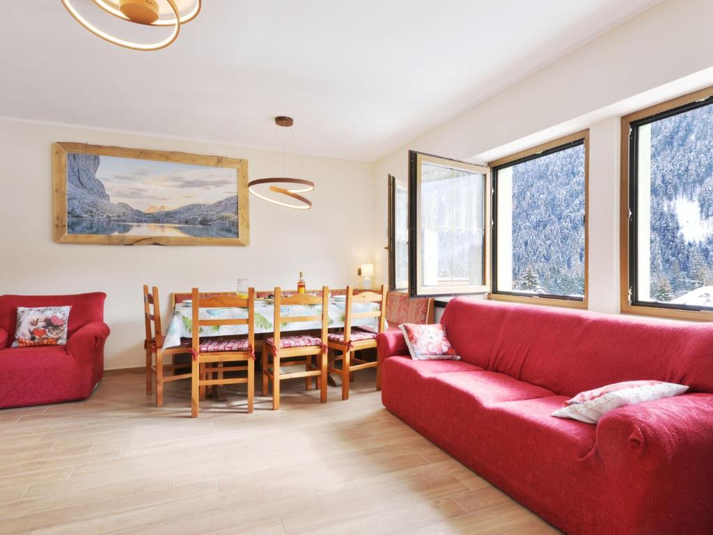 uma sala de estar com um sofá vermelho e uma mesa em Apartment Bernard-3 by Interhome em Campestrin